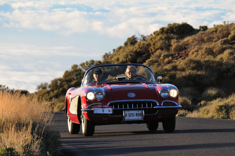 foto de un chevrolet corvette de los 50 rojo, por carretera en un atardecer